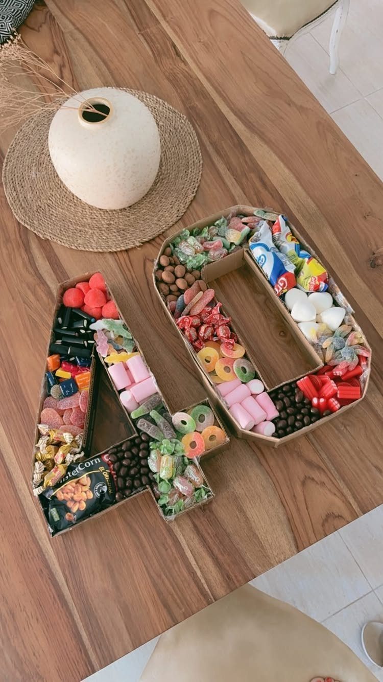 Candy filled cardboard containers shaped like the number 40 on a wooden table.