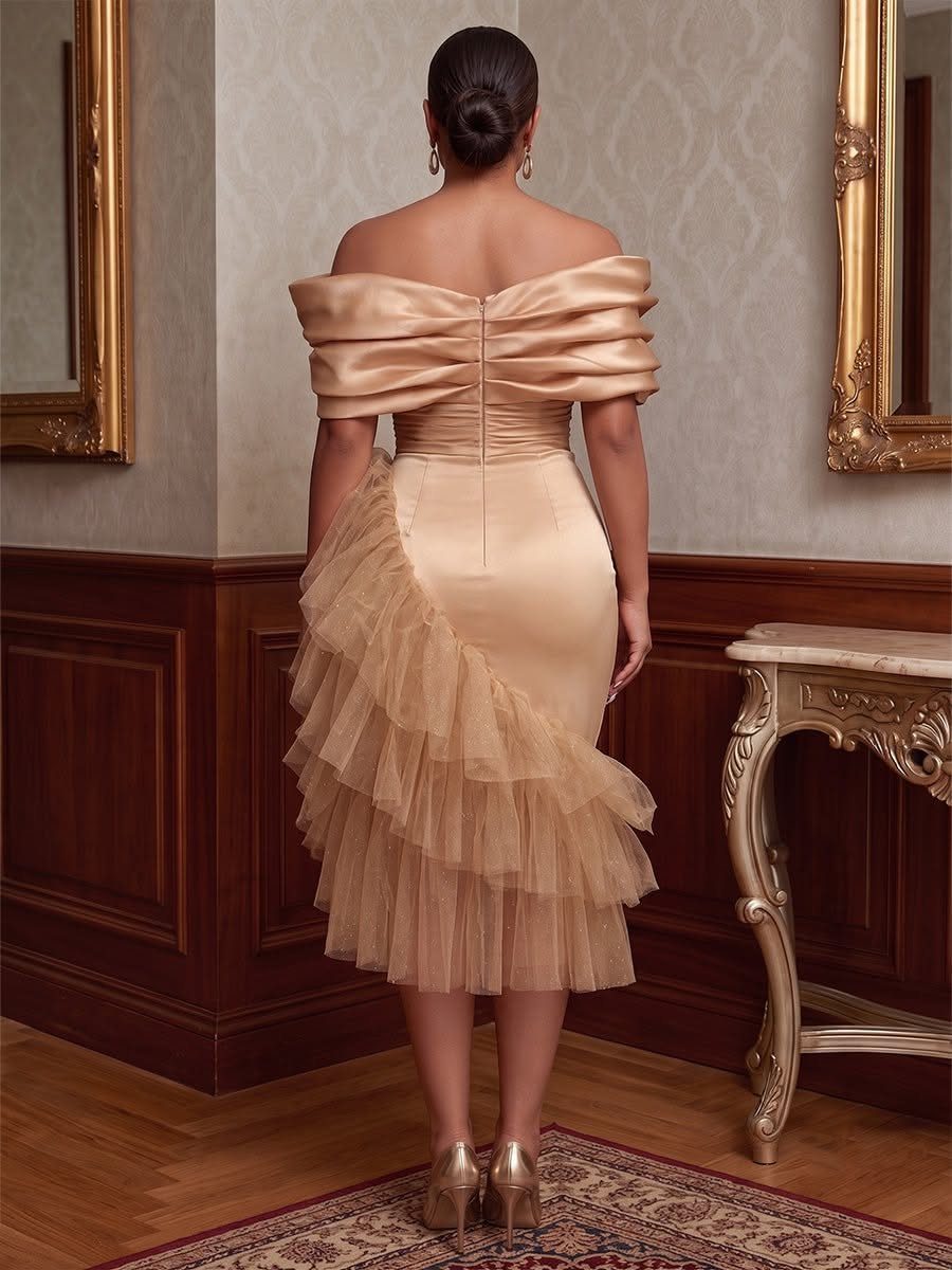 Woman wearing a gold satin midi dress with a ruffled tulle overskirt