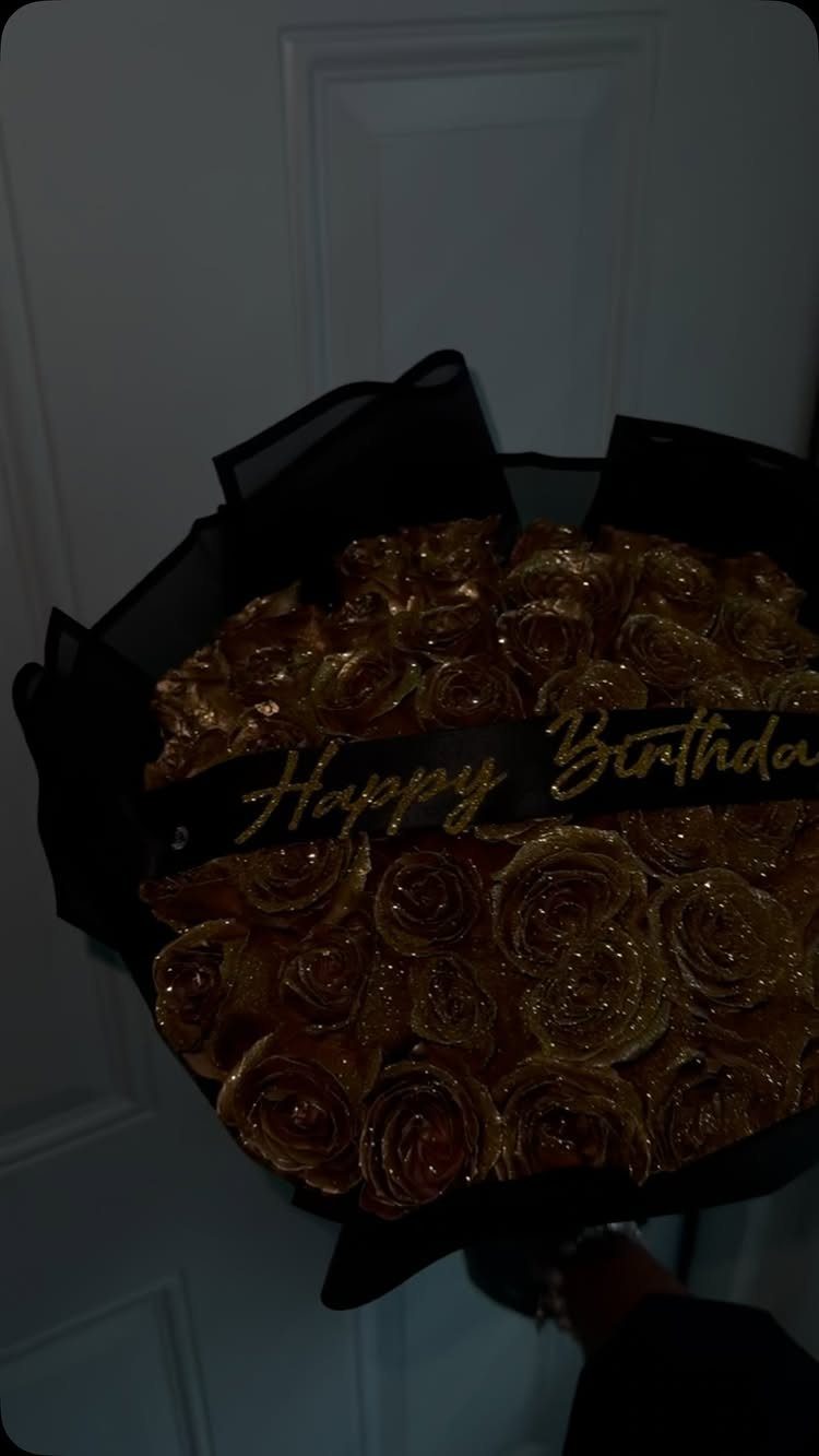 Bouquet of glittery gold roses wrapped in black paper with a birthday ribbon.