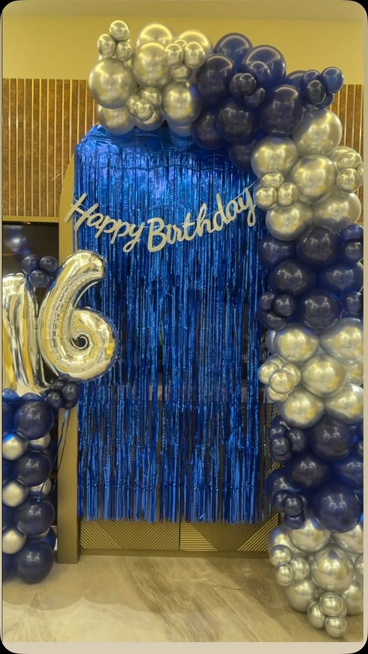 Blue and silver balloon arch with a number 16 balloon and birthday banner.