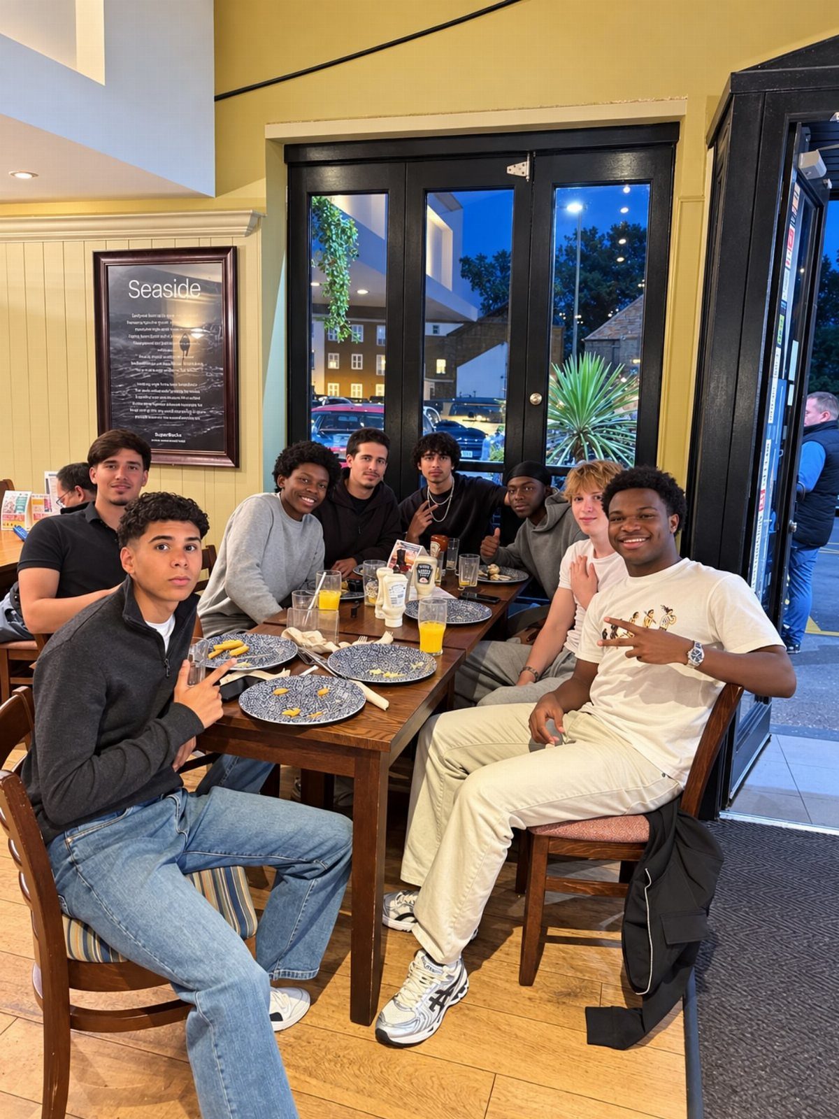 Group of teenage boys posing around a dinner table in a restaurant.