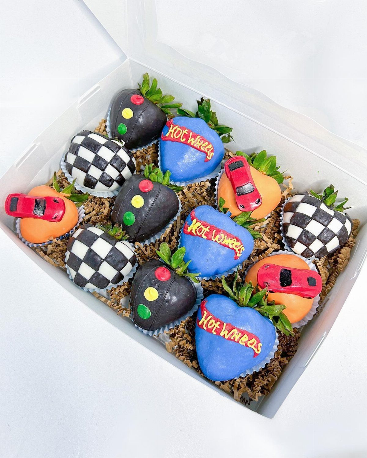Chocolate coated strawberries decorated as traffic lights, race cars, and checkered flags.
