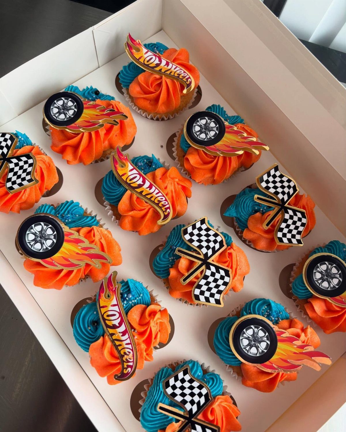 Hot Wheels themed cupcakes with orange and blue frosting and car decorations