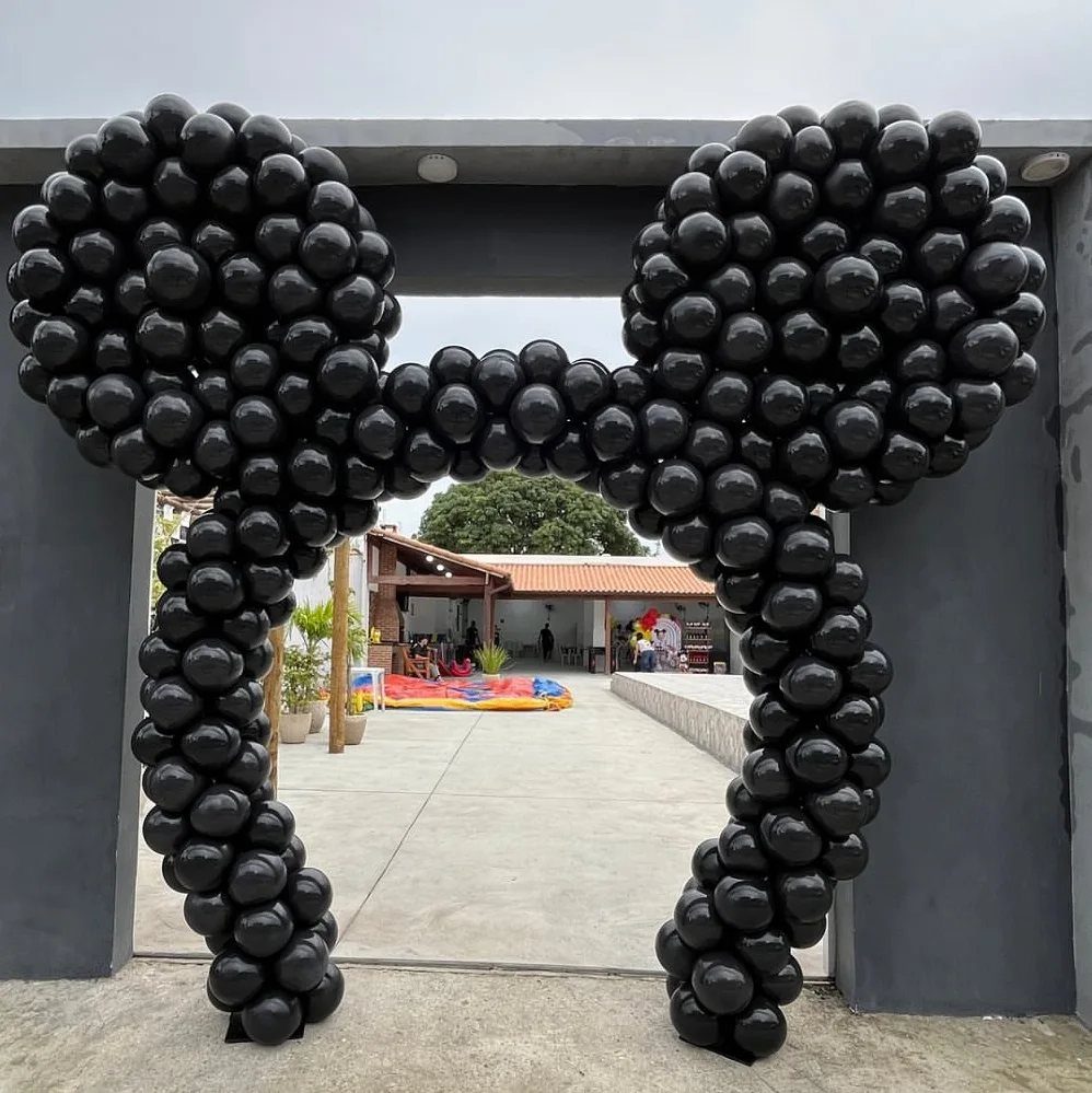 Mickey Mouse shaped balloon arch made of black balloons framing an outdoor entrance
