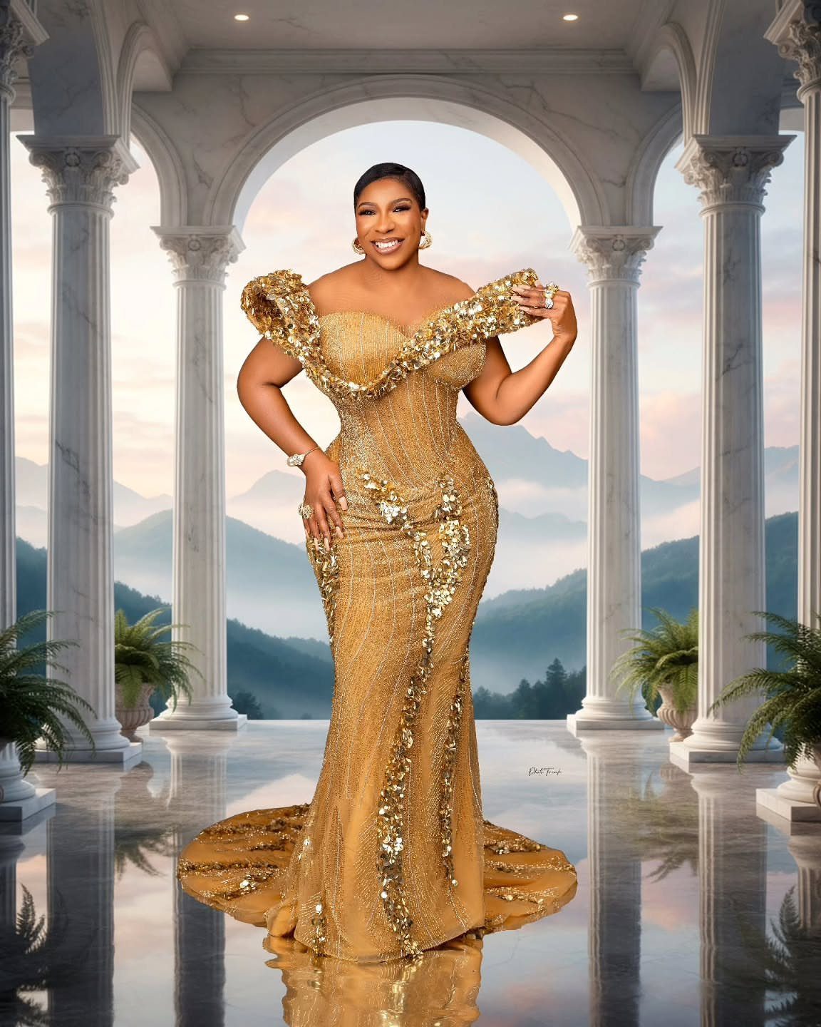 Woman in a glamorous floor-length gold sequin gown posing in a marble colonnade.