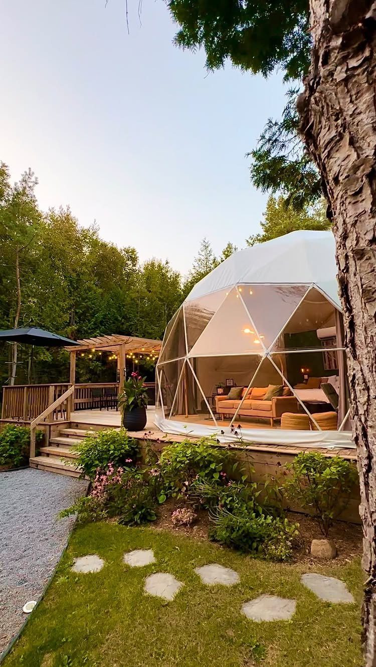Geodesic dome tent with a cozy interior on a wooden deck in the woods