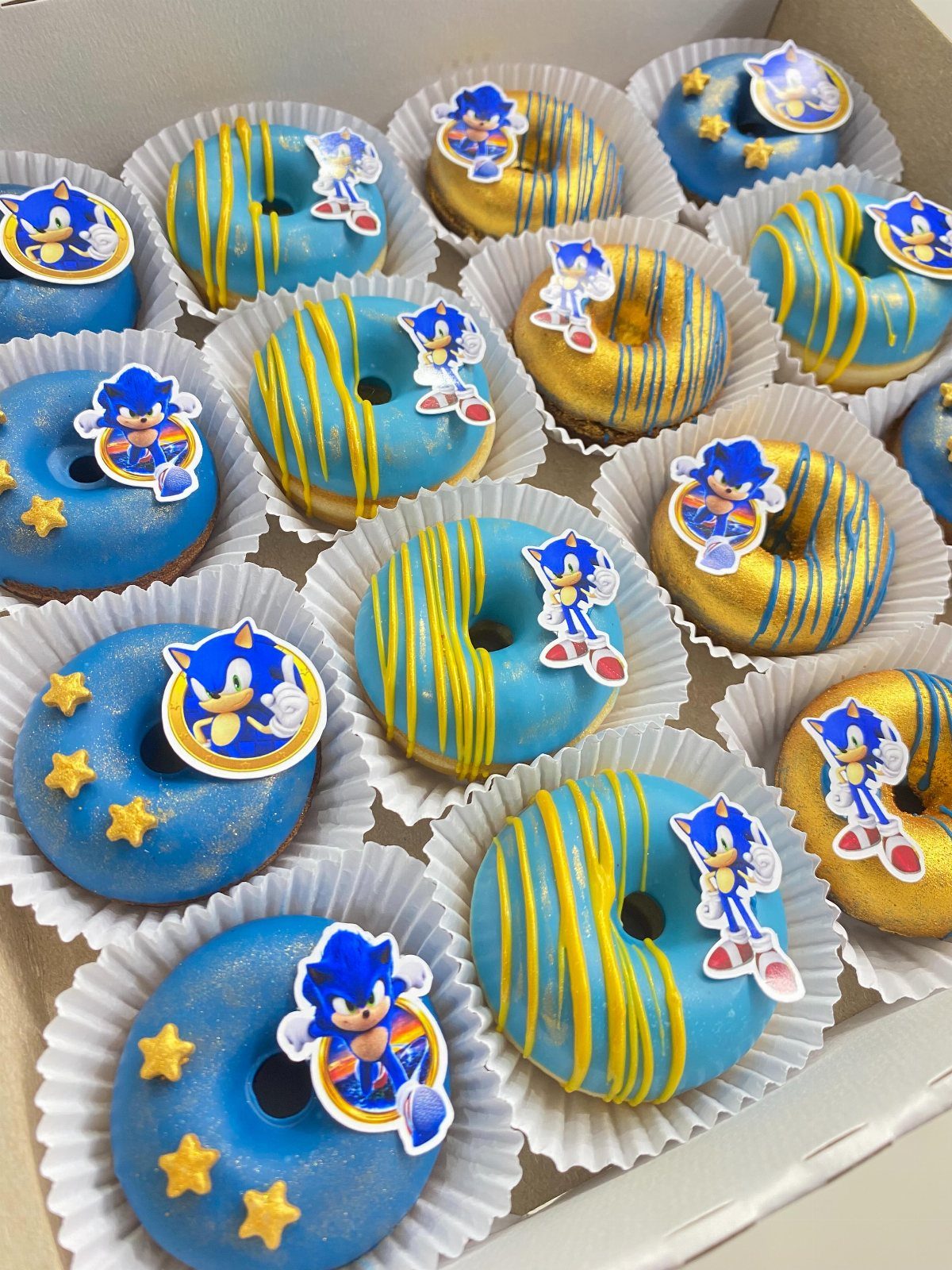 Blue and gold glazed donuts with Sonic the Hedgehog toppers in a box