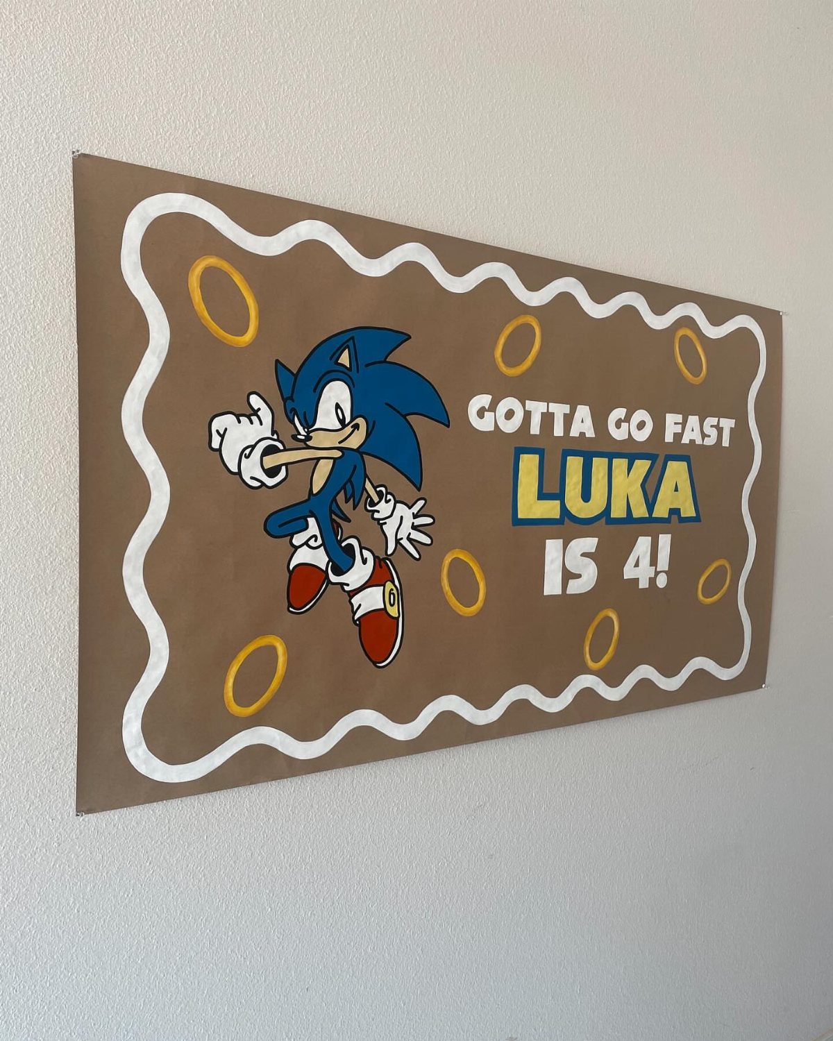 Sonic the Hedgehog birthday banner for Luka's 4th birthday on a white wall