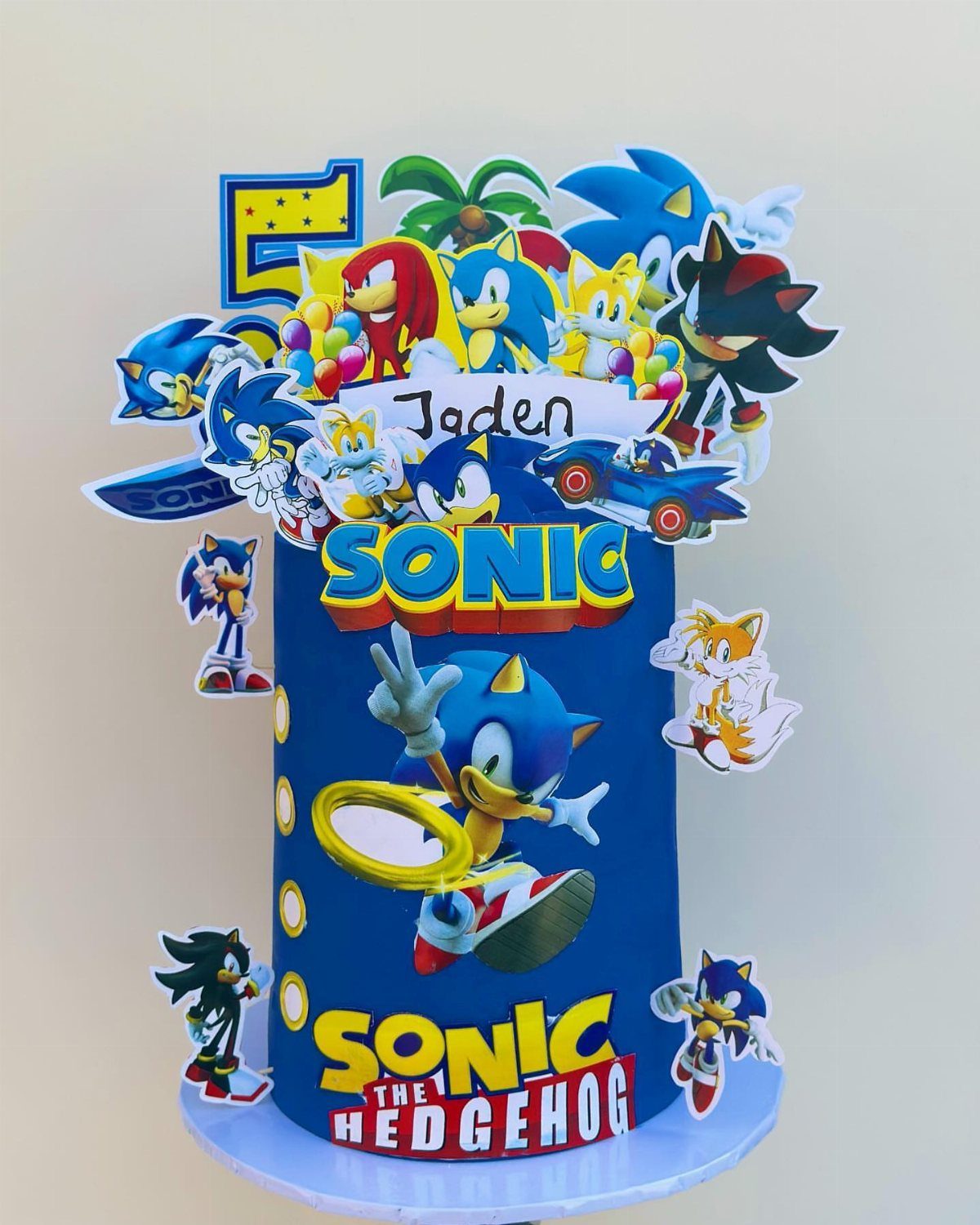 Sonic the Hedgehog themed birthday cake with character toppers and a gold ring.