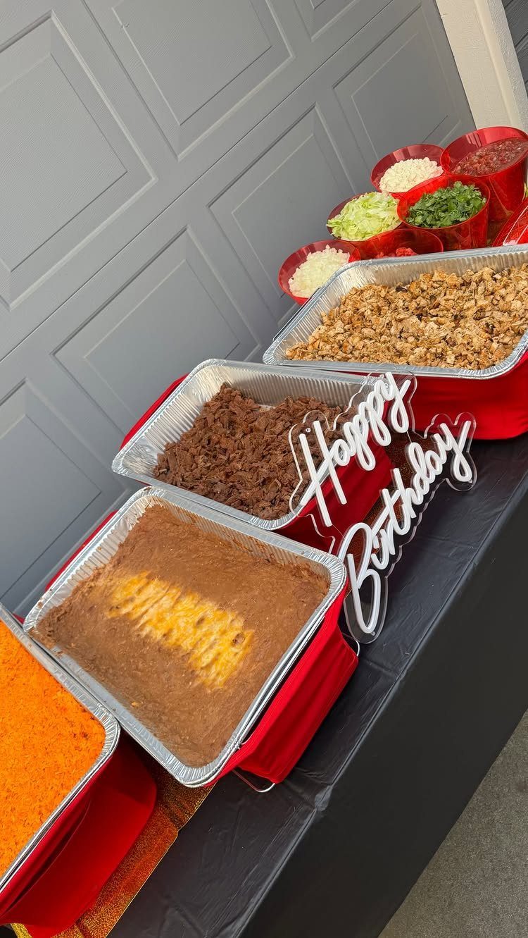Taco buffet spread with meat, beans, and toppings for a birthday party.