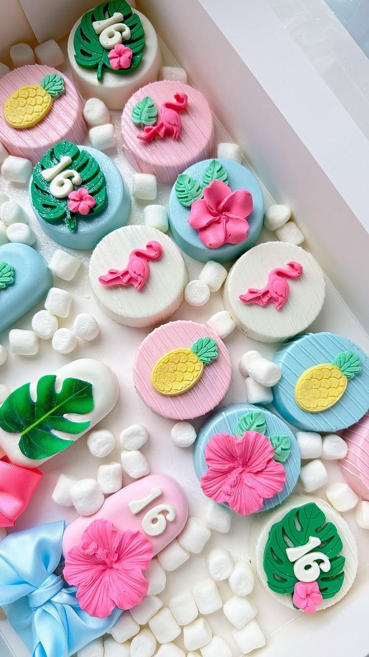Tropical themed chocolates with pineapples, flamingos, and the number 16 on a tray.