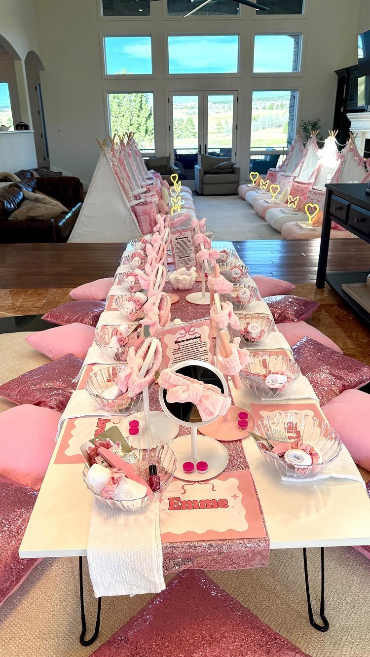 Pink themed party setup with a long table and teepees in a living room
