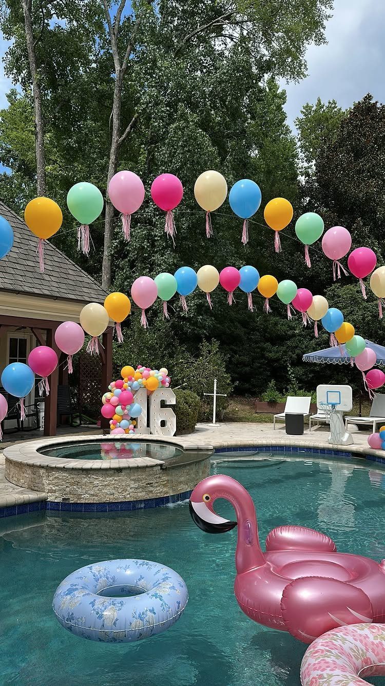 Swimming pool decorated with colorful balloon arches and inflatable flamingo for a party