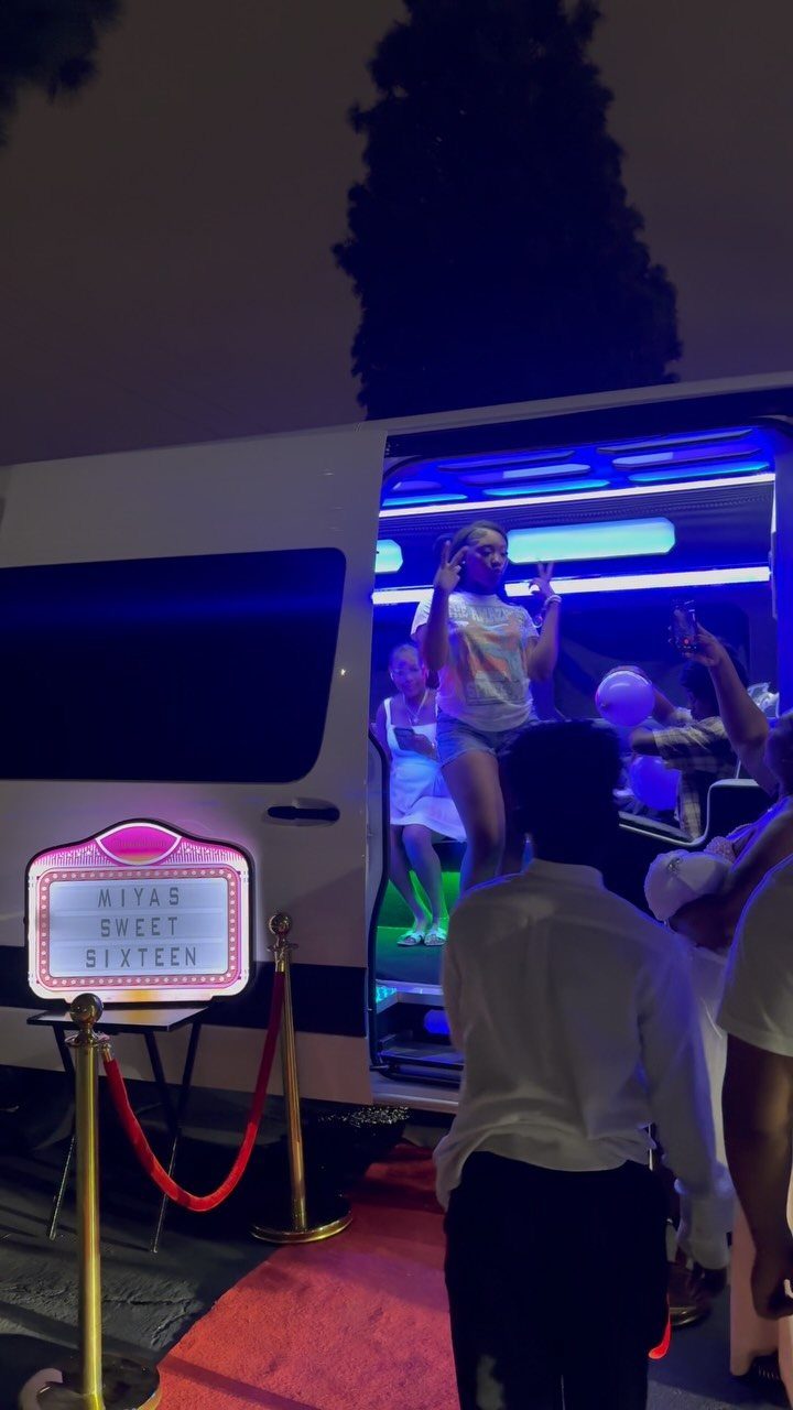 White party bus with blue lights and a Sweet Sixteen sign on red carpet